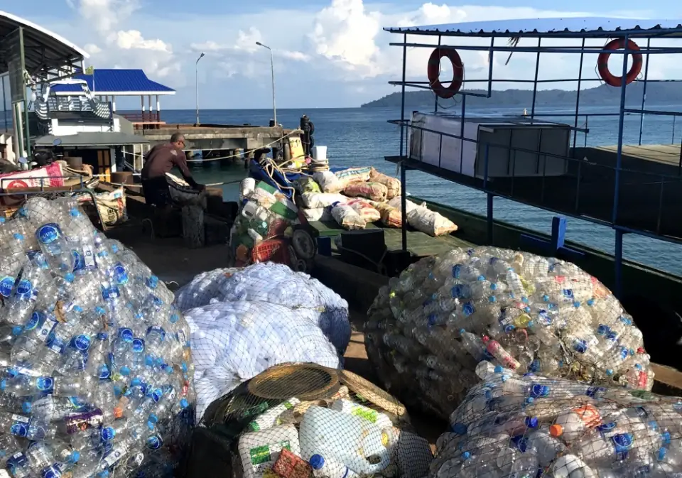 Bags of plastic bottles collected for recycling at a Koh Mak pier
