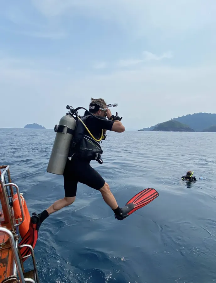 Scuba diver swimming over a tropical coral reef near Koh Mak