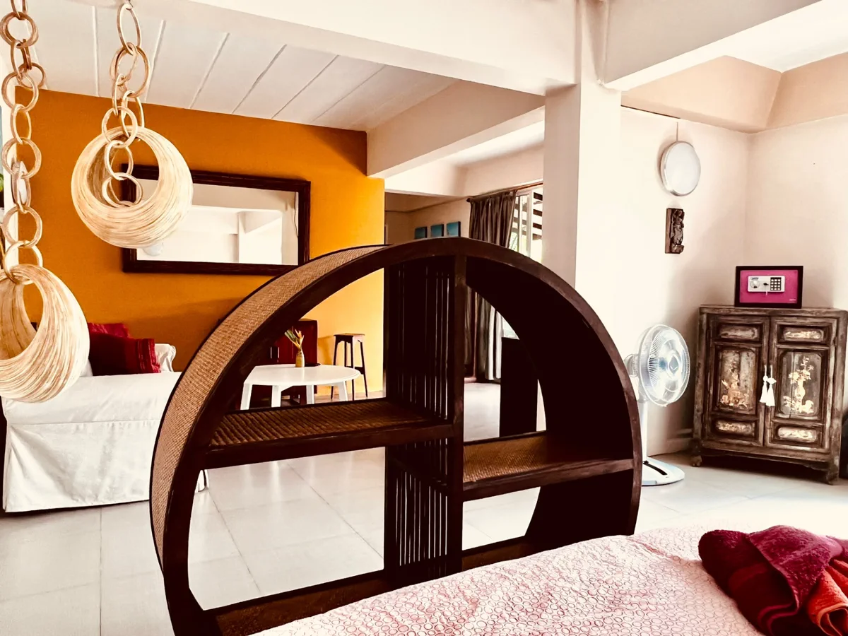Garden Studio interior with circular wooden partition and warm tropical decor at Koh Mak Village
