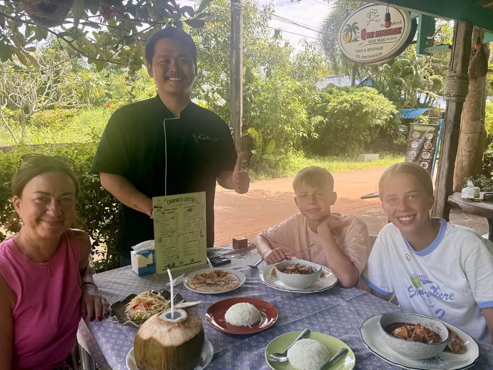 Qbar owner Mr. Q with guests at the open-air restaurant in Ao Kao, Koh Mak