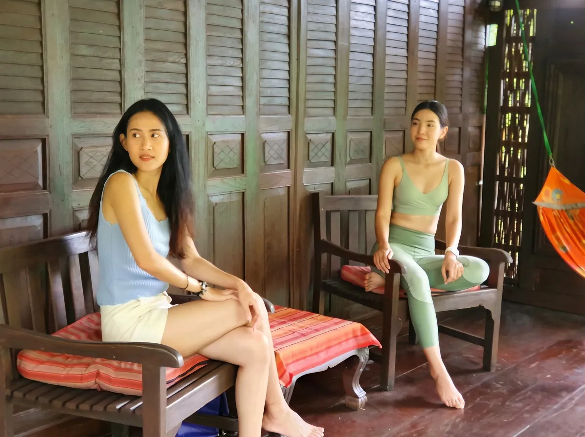 Two women relaxing on a Thai-style wooden veranda on Koh Mak
