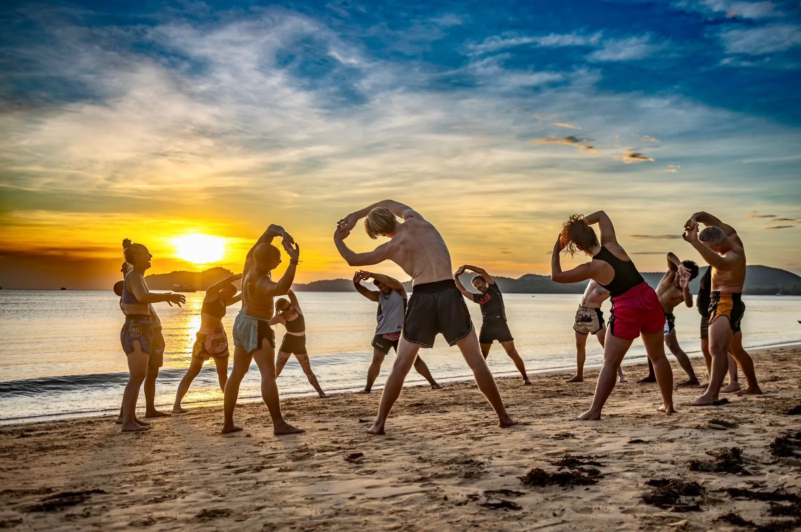 Muay Thai students stretching on Koh Mak beach at sunset