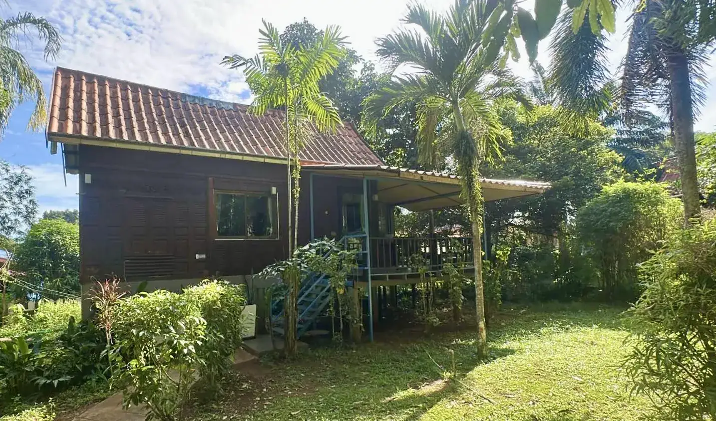 Traditional Thai-style Champu house with bicycles and tropical garden on Koh Mak