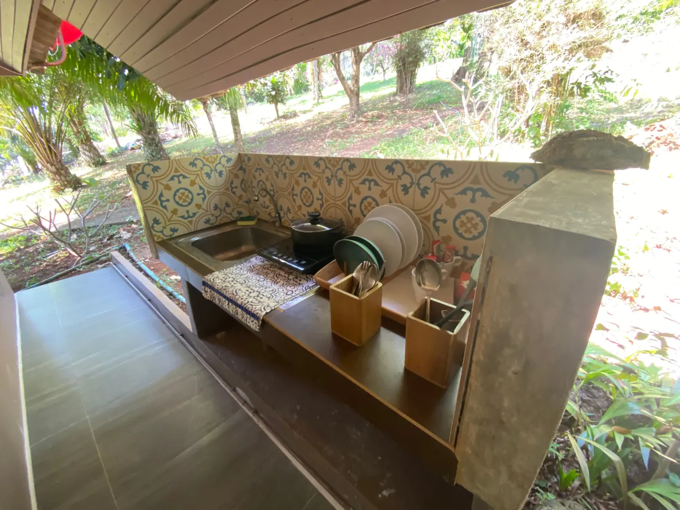 Basic outdoor kitchenette with sink, induction hob and patterned tiles at Rambutan House, Koh Mak