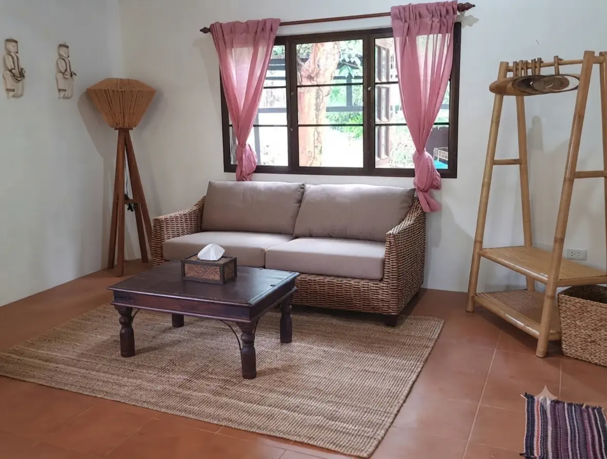Bright private lounge with wicker sofa and Thai-style wooden furniture at Pineapple Villa on Koh Mak