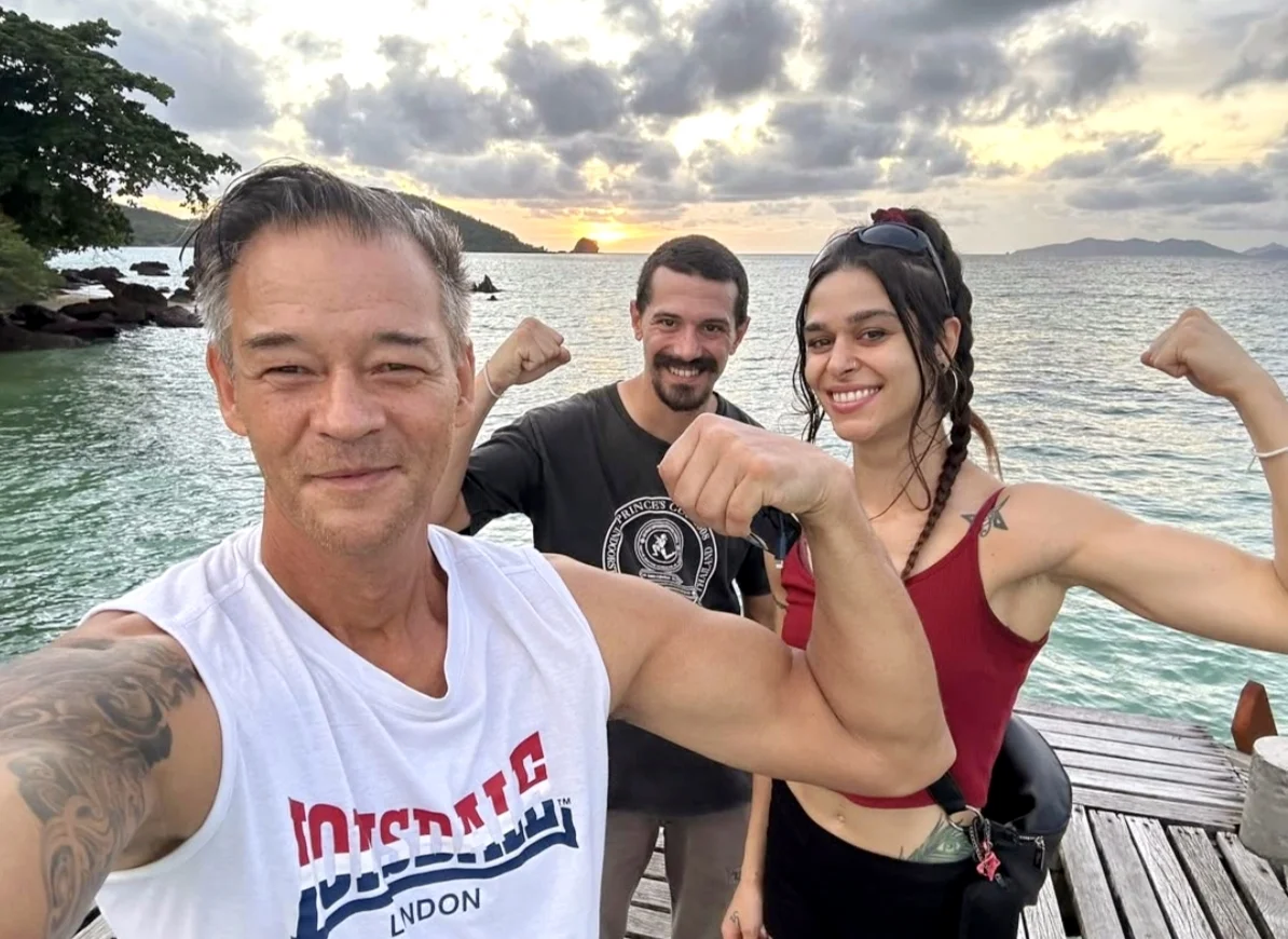 Muay Thai and Kung Fu professionals training together on a Koh Mak beach at sunset