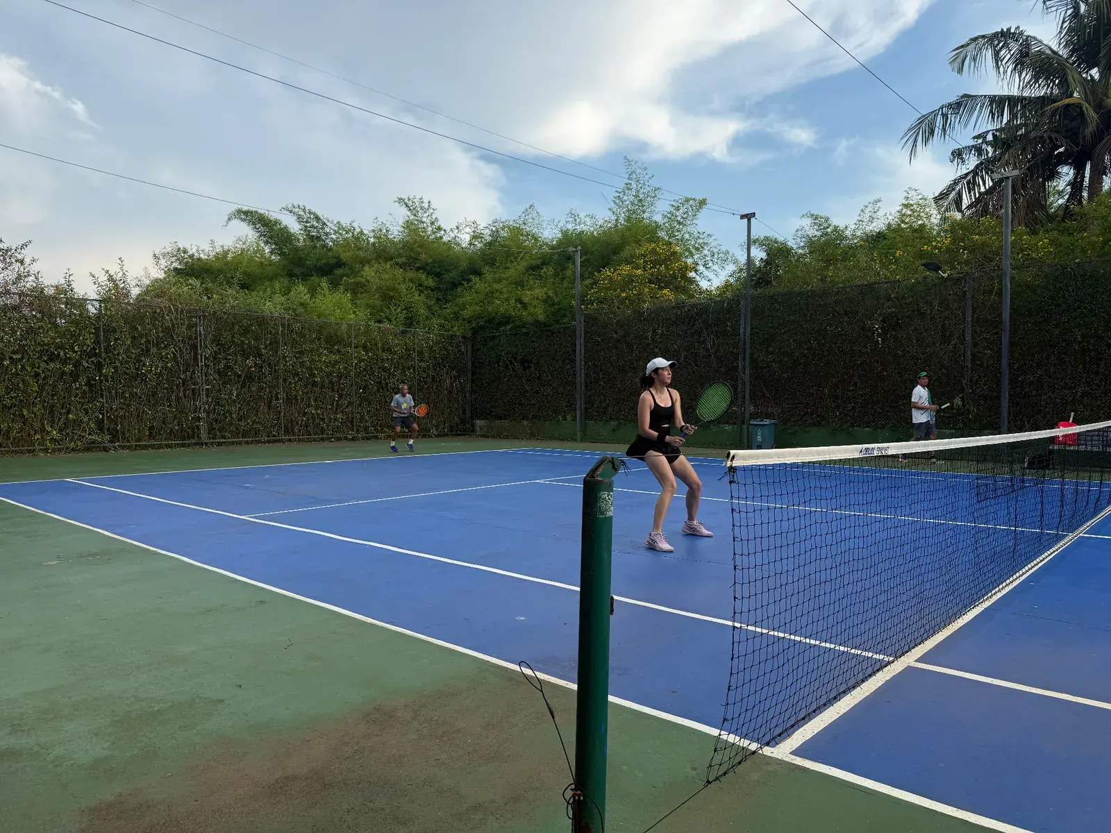 Doubles match on the outdoor tennis court at White Sand Beach Resort, Koh Mak