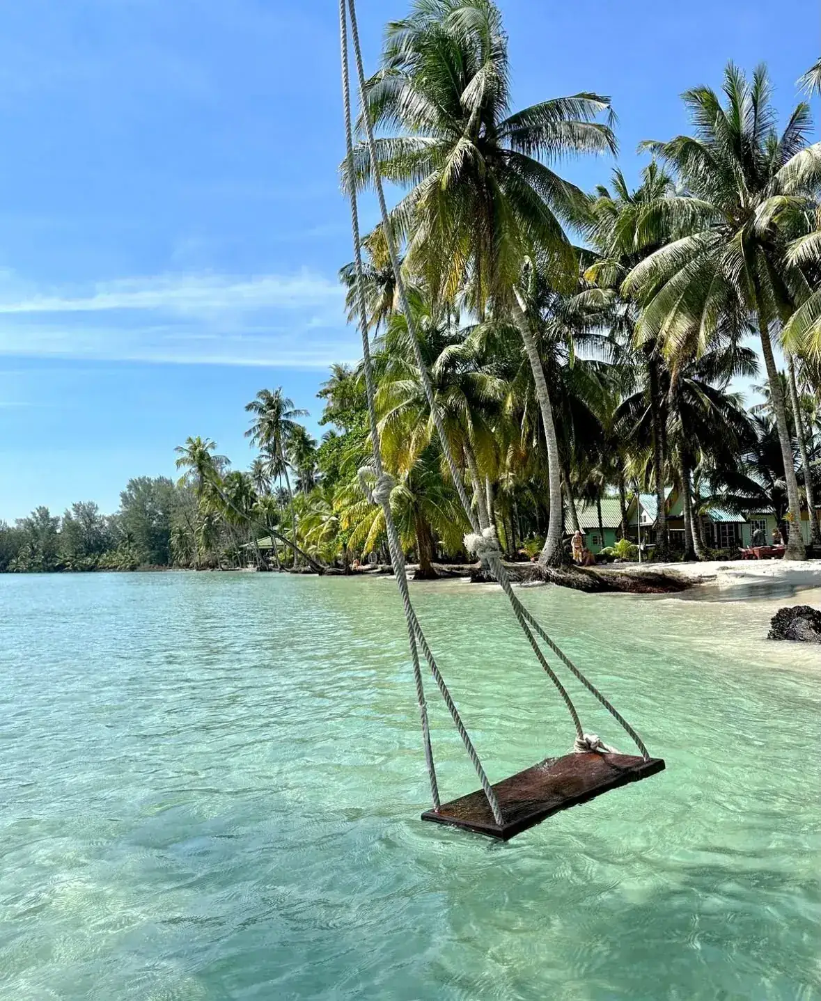 Wooden rope swing over crystal-clear turquoise water at Ao Kao Beach, Koh Mak, Thailand