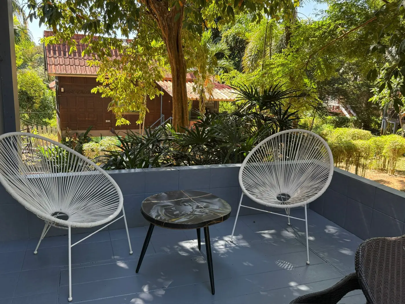 Private terrace with Acapulco chairs and garden view at Sugarcane Villa, Koh Mak