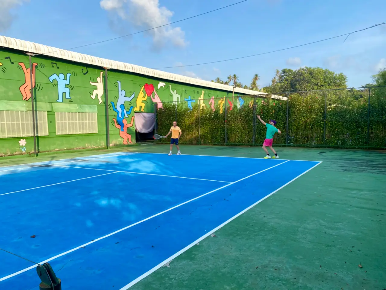 Outdoor tennis court at White Sand Beach Resort, Koh Mak, with colourful mural wall