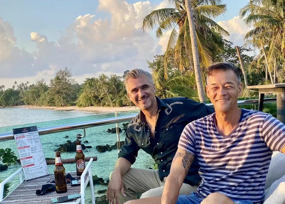 Two guests enjoying sunset drinks on the White Sand Beach Resort rooftop terrace overlooking Ao Kao