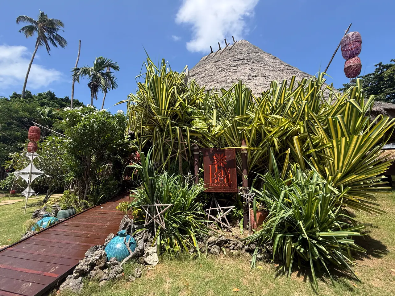 Day Bed Beach Club at Seavana Beach Resort, Ao Suan Yai, Koh Mak — tropical garden entrance with a thatched-roof hut