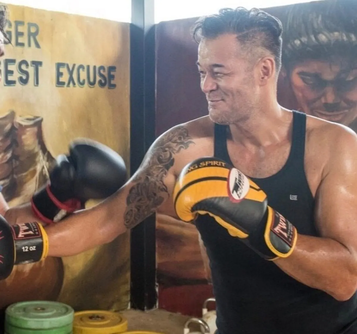 Guest training boxing with gloves inside the Koh Mak gym
