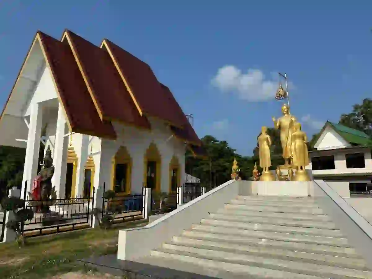 Golden Buddha statues and traditional Thai temple architecture on Koh Mak