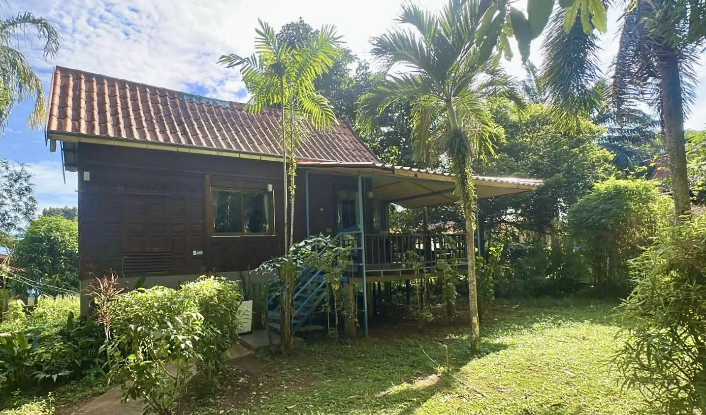 Traditional Thai-style Champu house with bicycles and tropical garden on Koh Mak