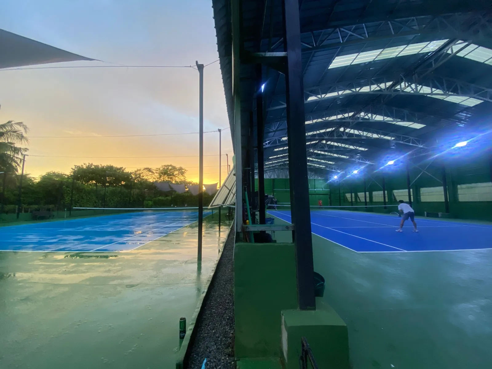 Indoor and outdoor tennis courts side by side at sunset on Koh Mak