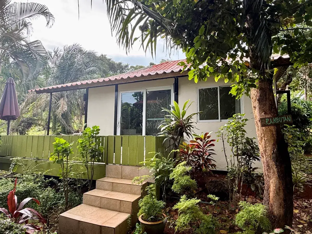 Rambutan House front exterior with tropical garden, green deck and red roof on Koh Mak, Thailand