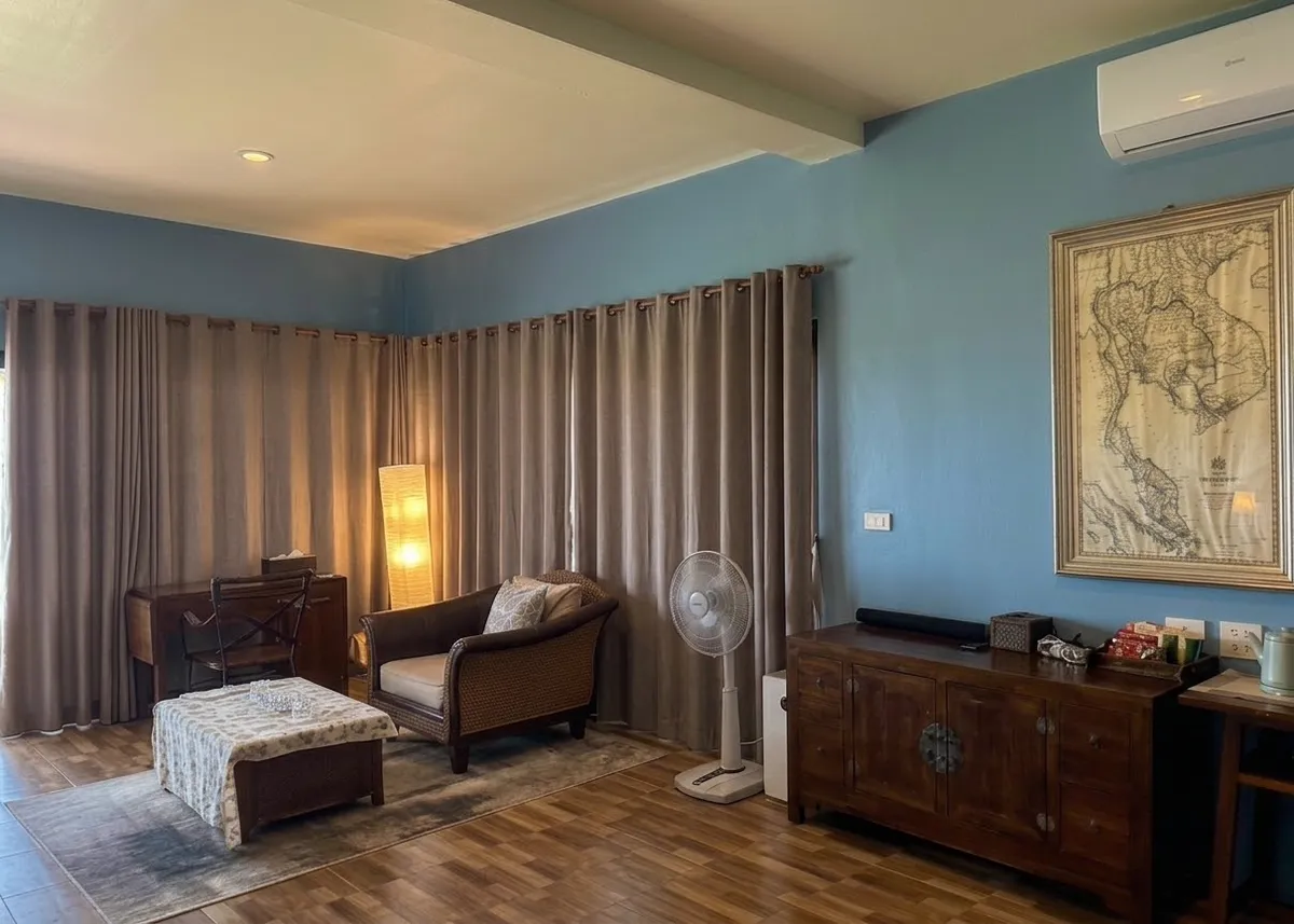 Interior living area of the Owners Beachfront Villa with desk, sofa, cabinet and vintage map, Koh Mak, Thailand